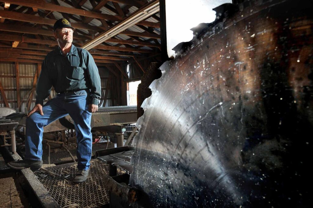 The State of Montana Forestry 3 Kelly Gephardt, owner of Gephardt Post Plant & Sawmill, stands in the sawmill of his Roundup, Montana plant. (AP photo/James Woodcock, Billings Gazette.)